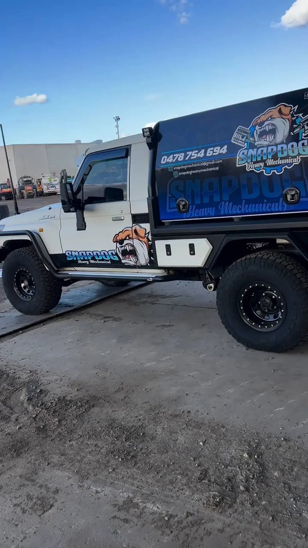 Side view of the white Land Cruiser tray-back with a blue canopy showing the SnapDog bulldog logo and the phone number 0478 754 694.