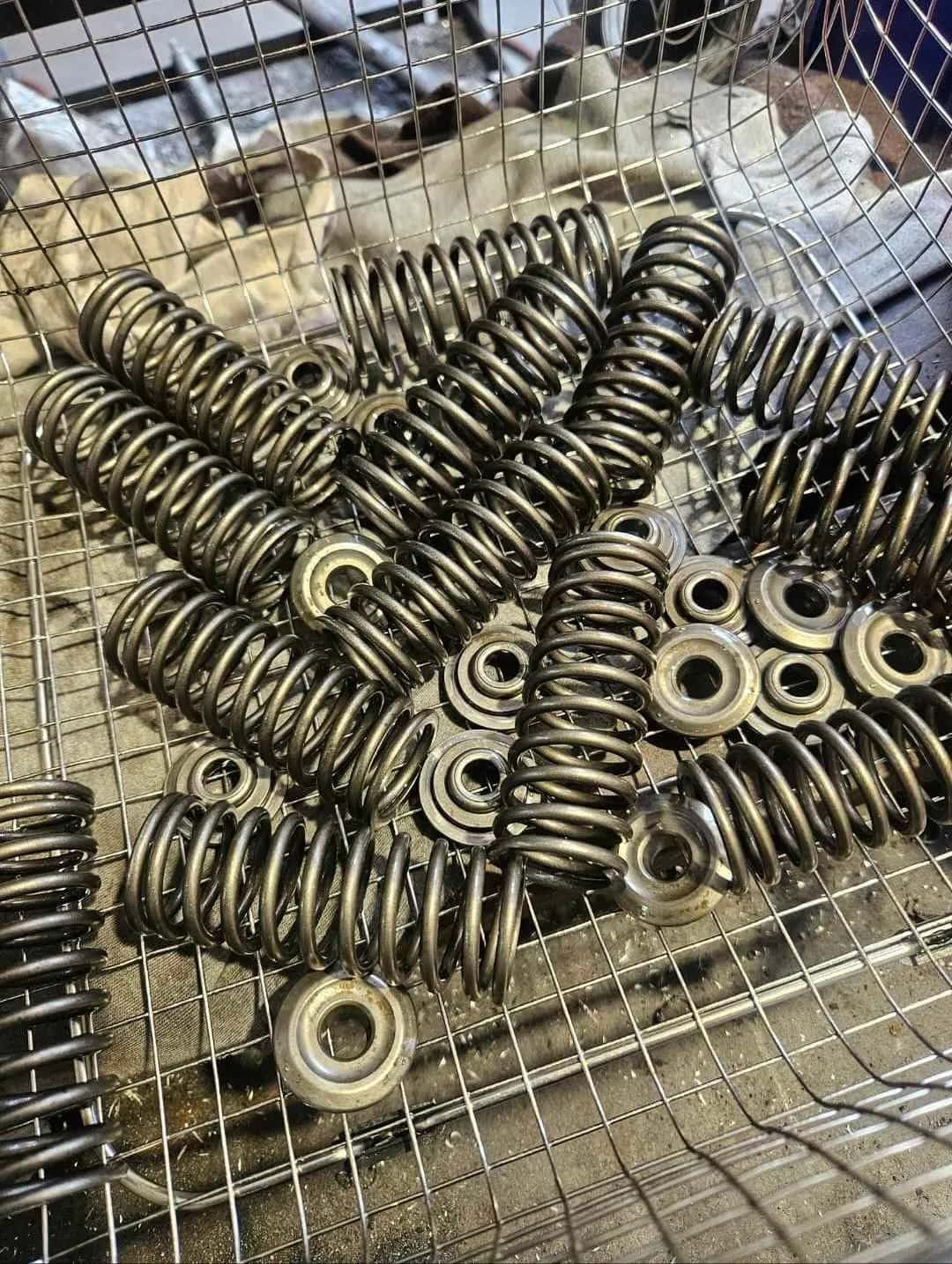 A wire basket of valve springs and spring retainers.